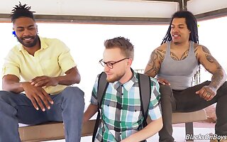 Interracial gay threesome on the sofa with two large black dicks
